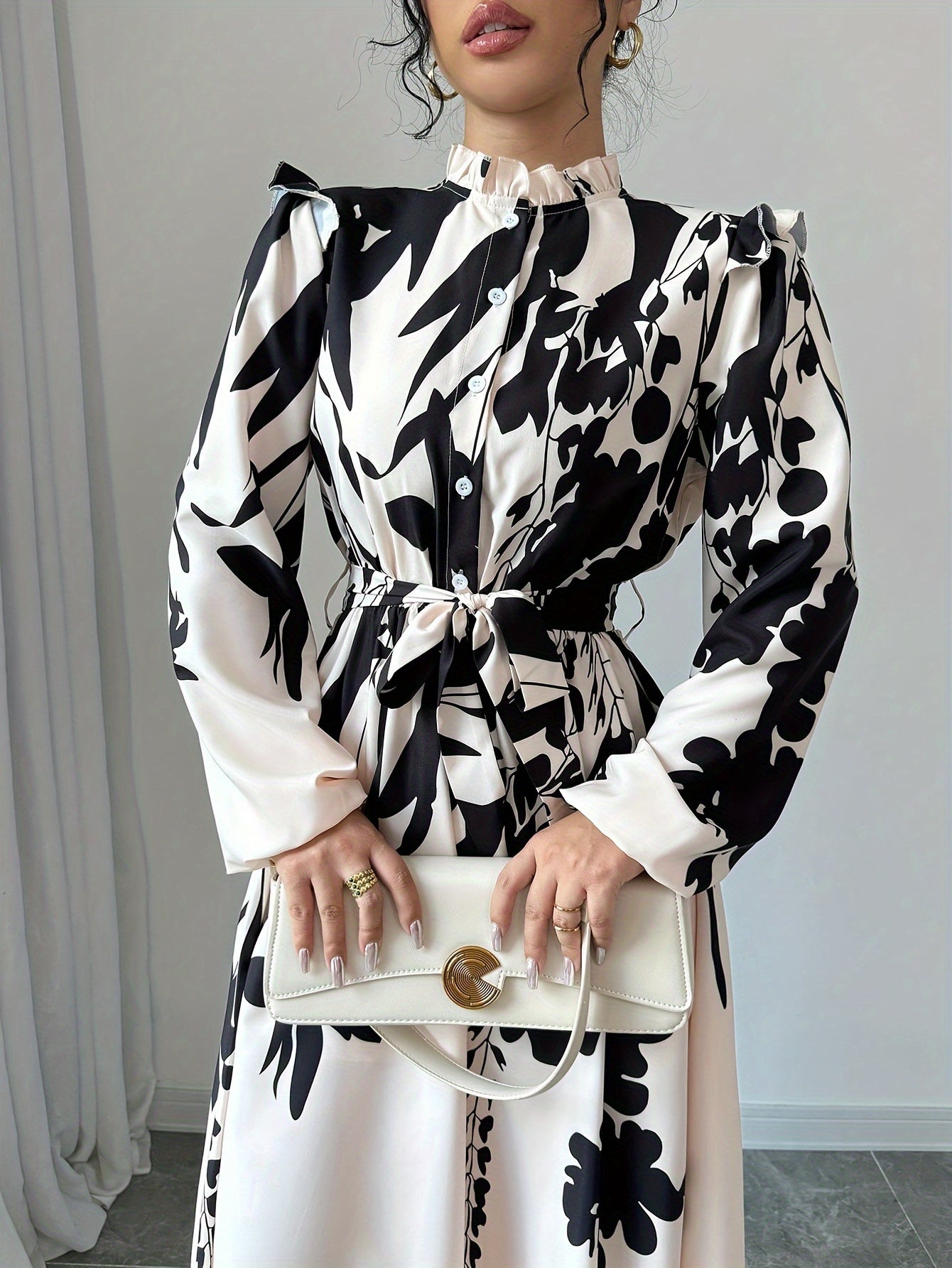 Elegant women's long sleeve shirtdress with a floral print, button-front closure, and belted waist, styled for fall/winter workwear.