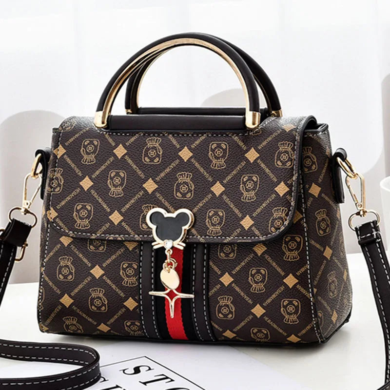 Designer handbag with a distinctive pattern and decorative charm on a white background