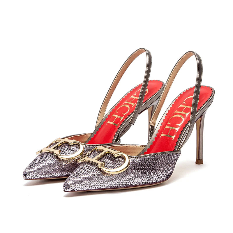 Silver glittery high-heeled shoes with red soles and gold accents on a white background