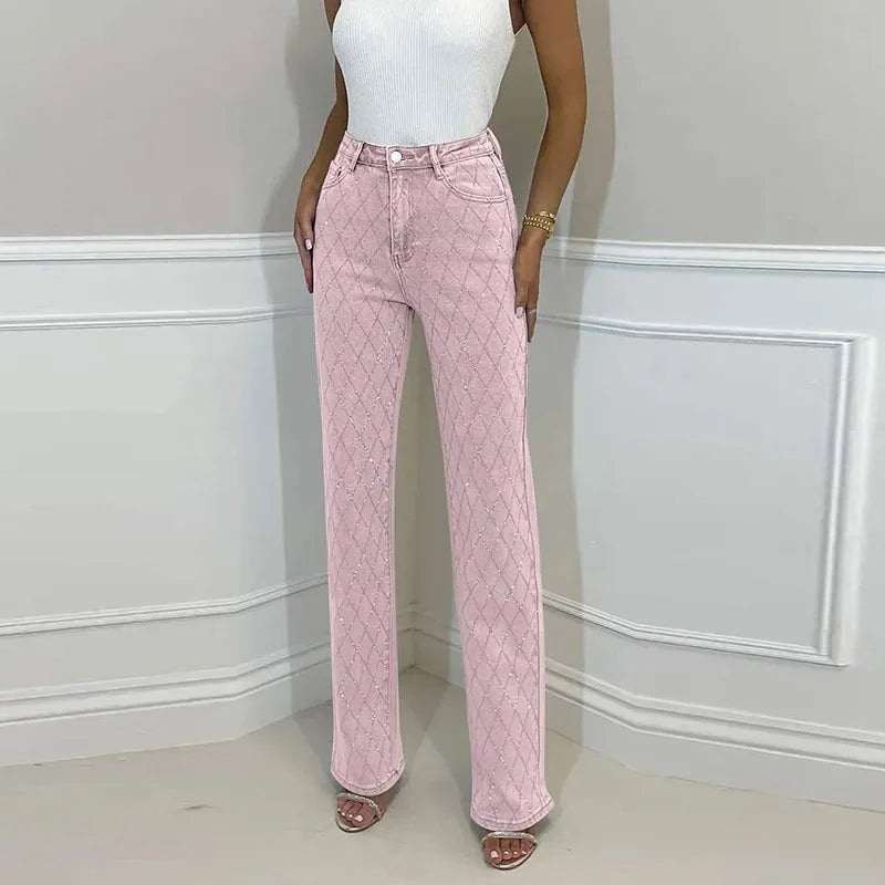 Person wearing pink quilted pants and a white top against a light gray wall. Women’s denim jeans with flower rhinestones, loose wide leg, low waist, light wash. Stylish rhinestone casual trousers for UK fashion lovers.