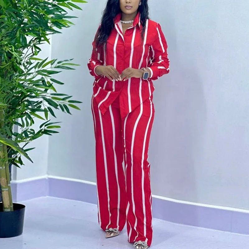 Woman wearing a striking red and white vertical stripe two-piece set, including a long-sleeve shirt and matching wide-leg pants.