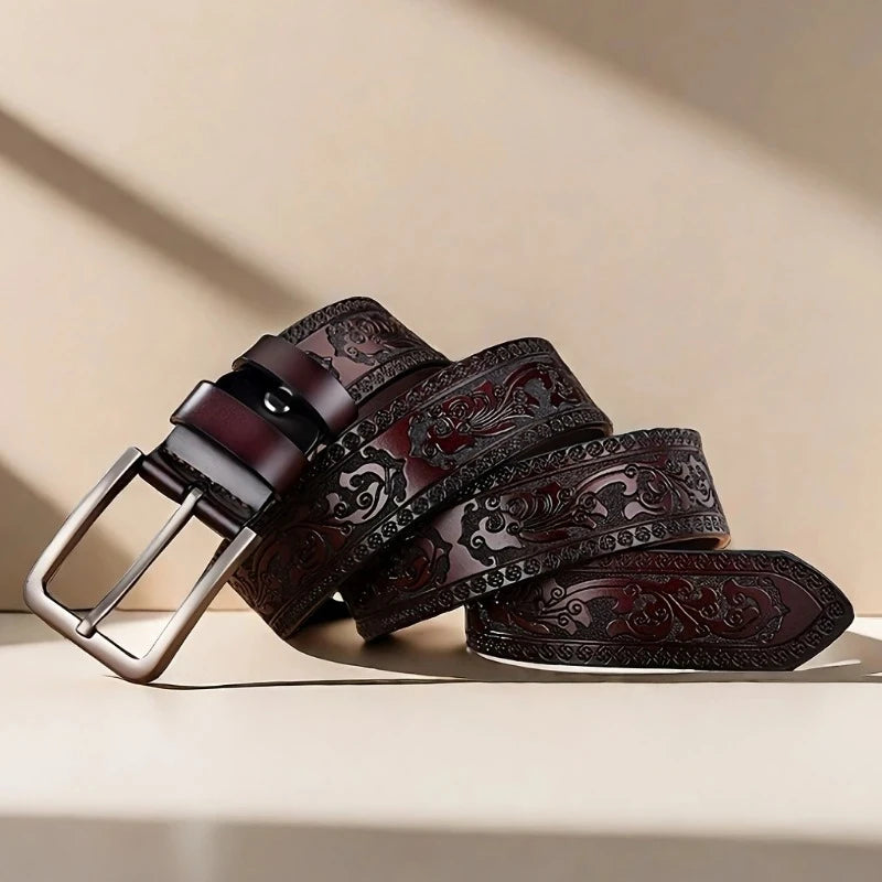 Brown leather belt with intricate designs on a beige background. Genuine split leather belt with retro western style and alloy buckle. Durable, stylish unisex belt for casual wear. Fast UK shipping.