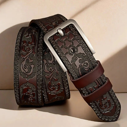 Decorative brown leather belt with intricate patterns on a beige background. Genuine split leather belt with retro western style and alloy buckle. Durable, stylish unisex belt for casual wear. Fast UK shipping.