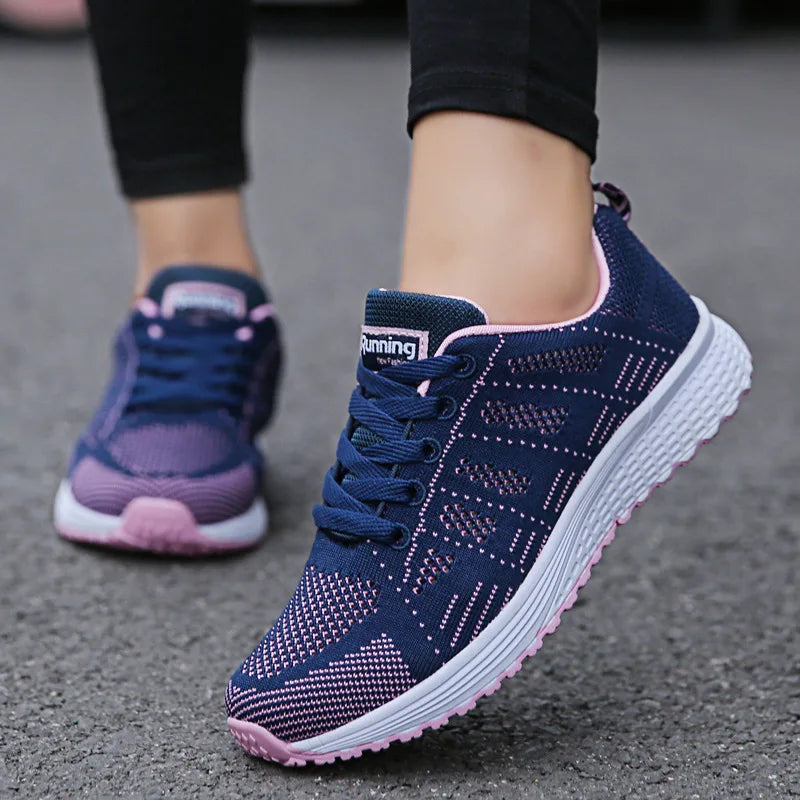 Navy and pink running shoes on a pavement background