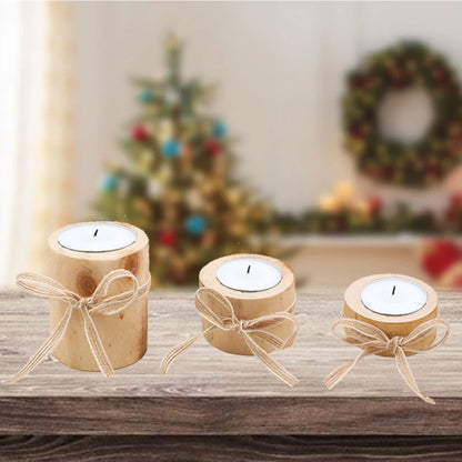 Three wooden candle holders with candles on a wooden surface, decorated with Christmas trees and wreaths in the background.