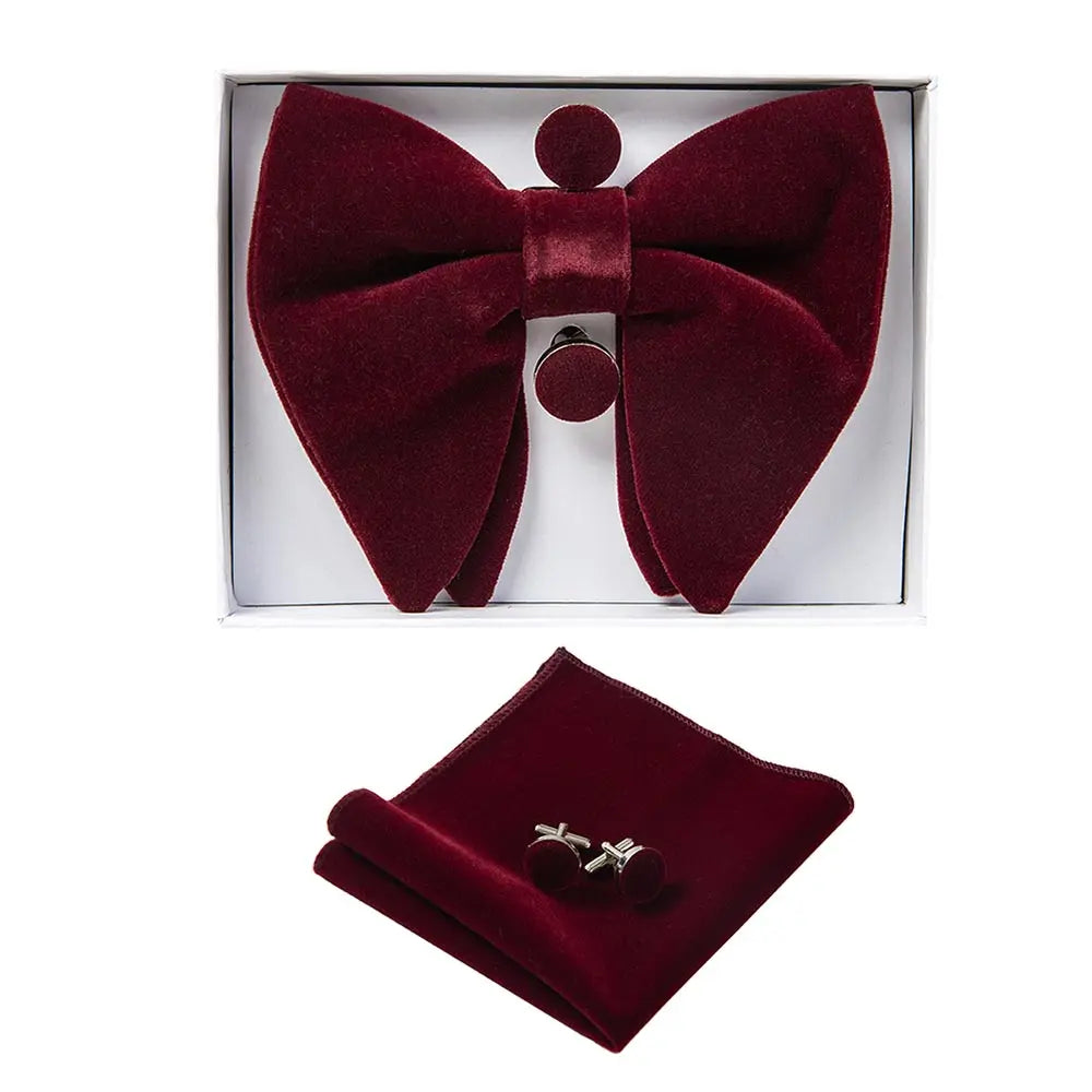 Burgundy bow tie, pocket square, and cufflinks set in a box on a white background