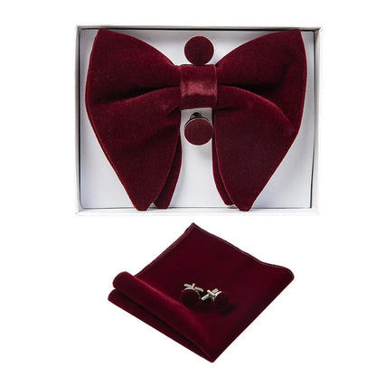Burgundy bow tie, pocket square, and cufflinks set in a box on a white background
