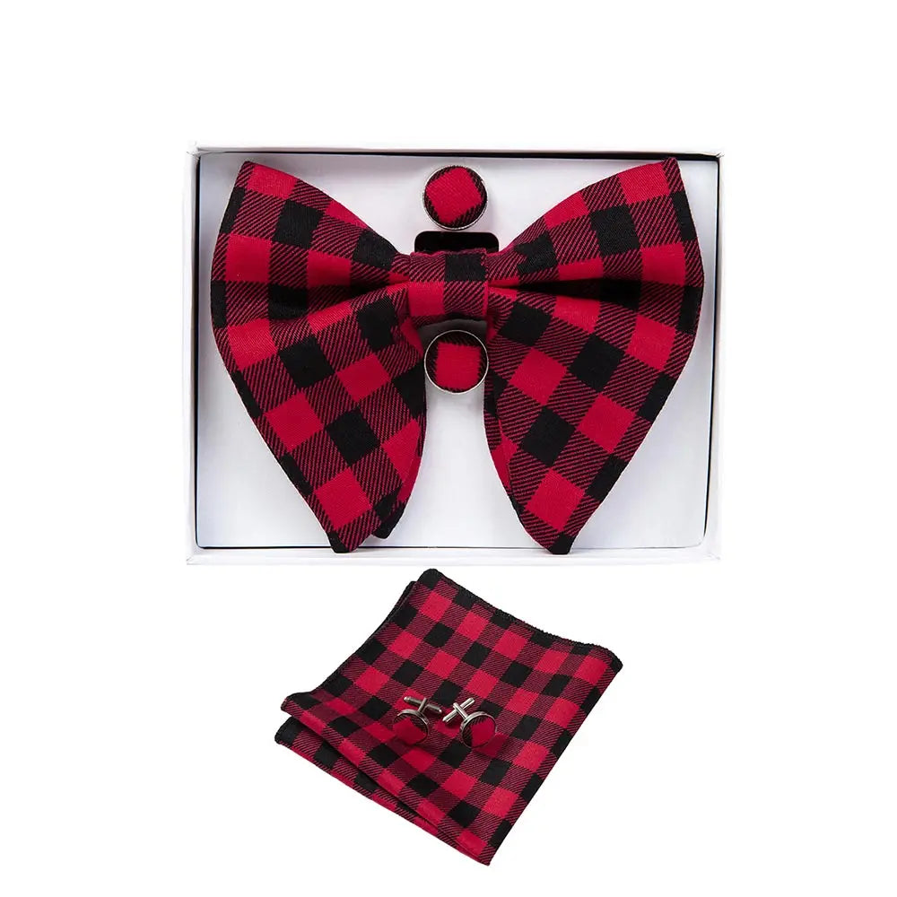 Red and black checkered bow tie, pocket square, and cufflinks set in a box on a white background