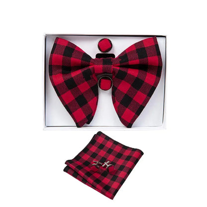 Red and black checkered bow tie, pocket square, and cufflinks set in a box on a white background