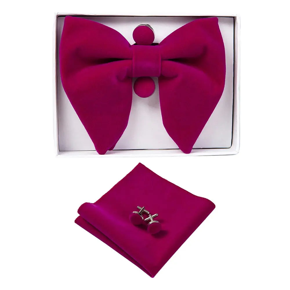 Set of pink bow tie, pocket square, and cufflinks in a box on a white background