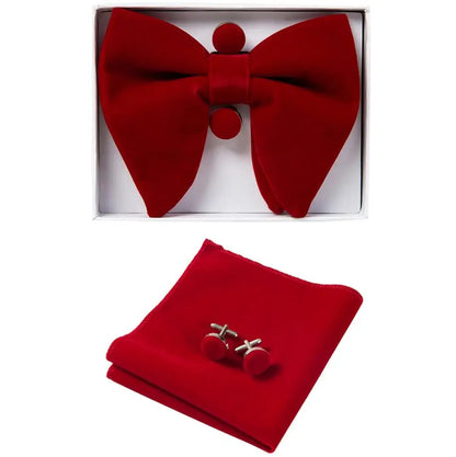 Red bow tie, pocket square, and cufflinks set in a box on a white background