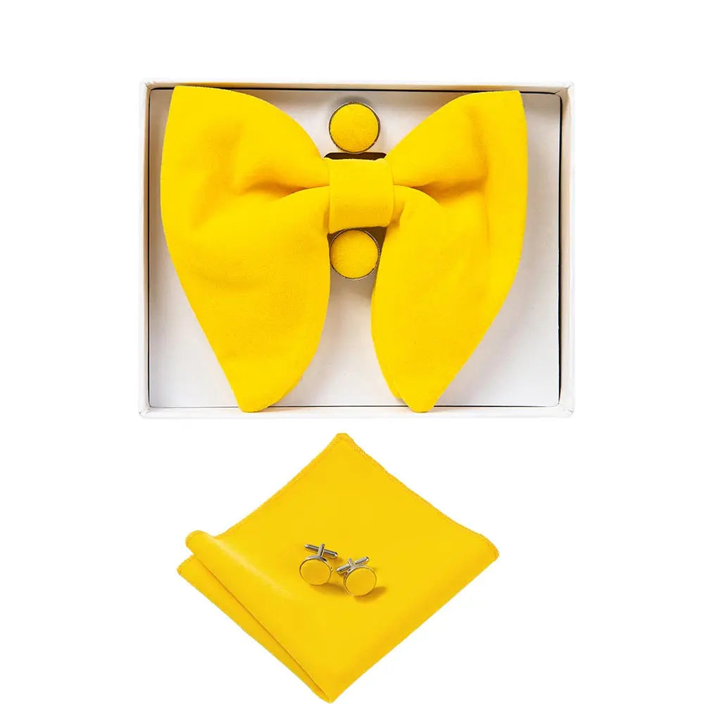 Yellow bow tie, pocket square, and cufflinks set in a box on a white background