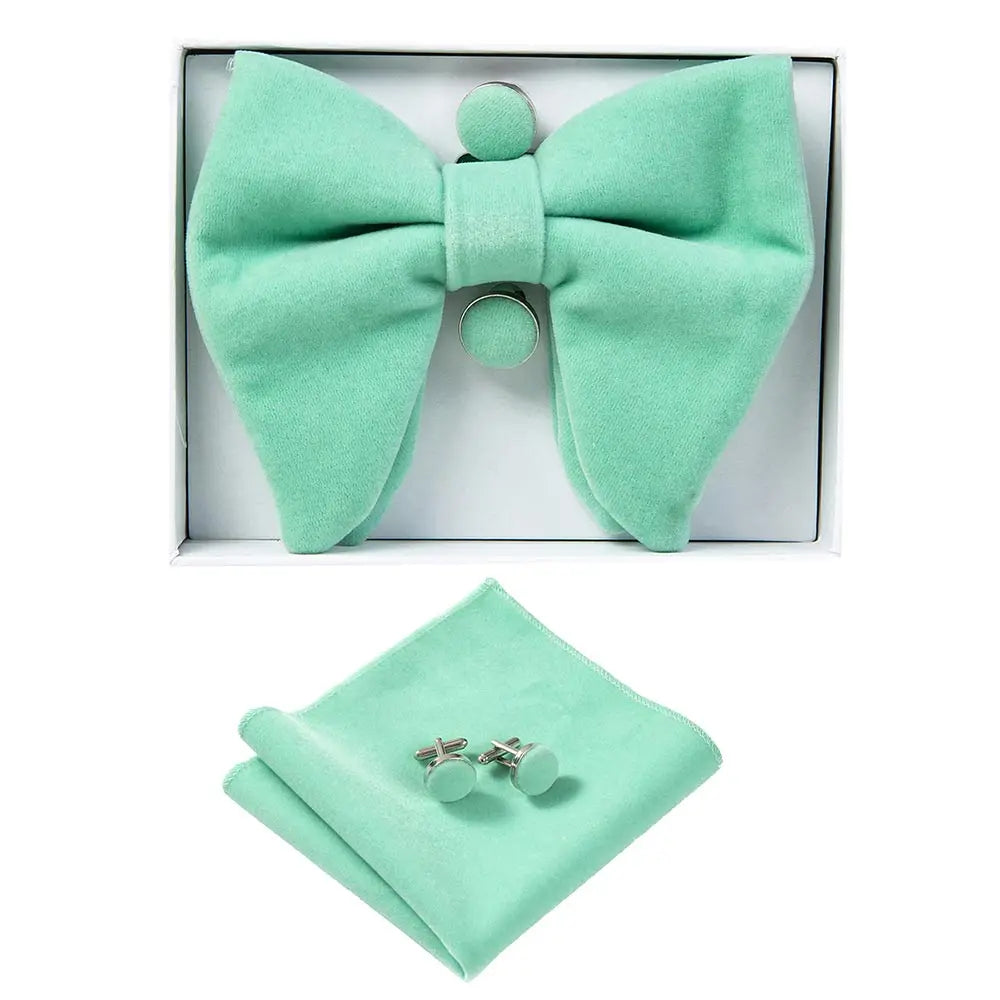 Mint green bow tie, pocket square, and cufflinks set in a box on a white background