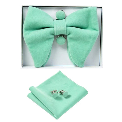 Mint green bow tie, pocket square, and cufflinks set in a box on a white background