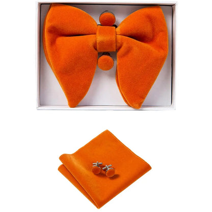 Orange bow tie, pocket square, and cufflinks set in a box on a white background