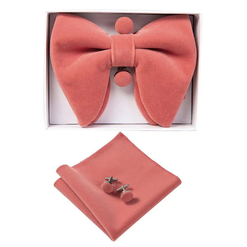 Coral bow tie, pocket square, and cufflinks set in a box on a white background