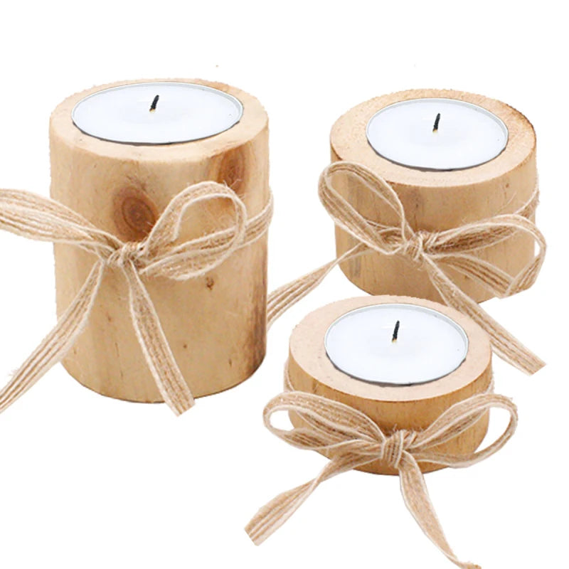 Three wooden candles with white candle holders and jute bows on a white background