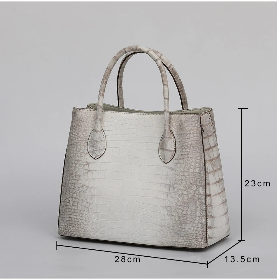 White crocodile-patterned handbag with dimensions on a gray background. Genuine crocodile leather tote bag for women, waterproof pillow shape with zipper closure and removable strap. Luxury high-quality fashion accessory.