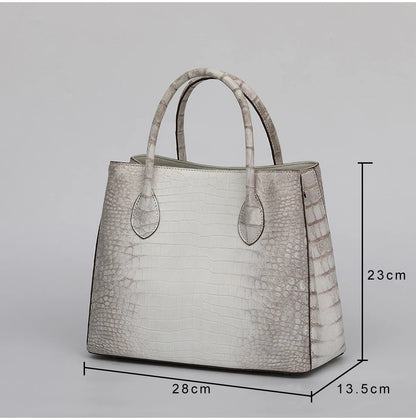 White crocodile-patterned handbag with dimensions on a gray background. Genuine crocodile leather tote bag for women, waterproof pillow shape with zipper closure and removable strap. Luxury high-quality fashion accessory.