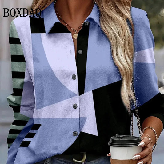 A woman wearing a geometric print button-up shirt with blue, black, and white shapes, holding a coffee cup. The brand name BOXDAQ is visible in the top left corner.