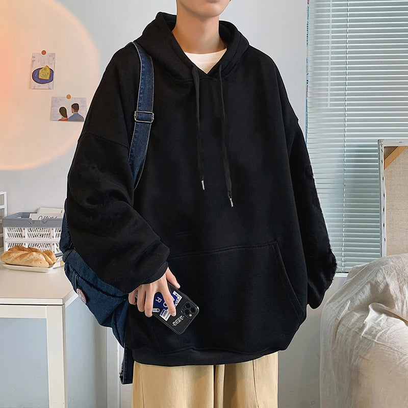 Person wearing a black hoodie with a backpack indoors