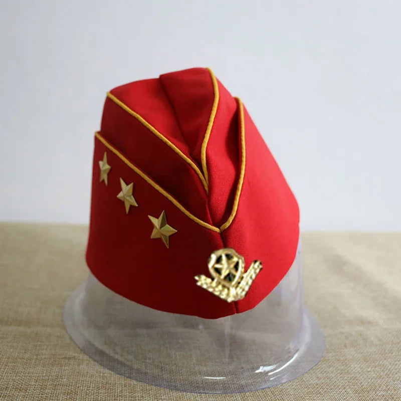Red military-style hat with gold accents on a clear stand against a light background