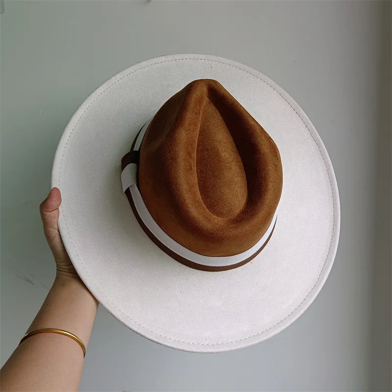 White hat with a brown interior held by a hand on a light gray background