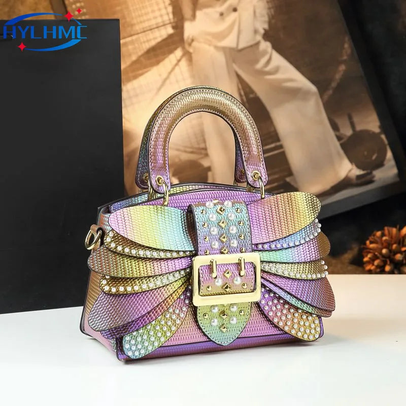 Multicolored handbag with decorative elements on a white surface. Women’s pearl riveted leather bag—animal print, trapezoid box shape, shoulder/crossbody style, soft handle, stylish UK fashion messenger handbag.