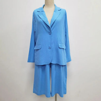 Image of a woman wearing a white Linen Look Blazer and Bermuda Shorts Co-ord Set with a brown belt and straw bag. Ideal smart casual summer outfit.