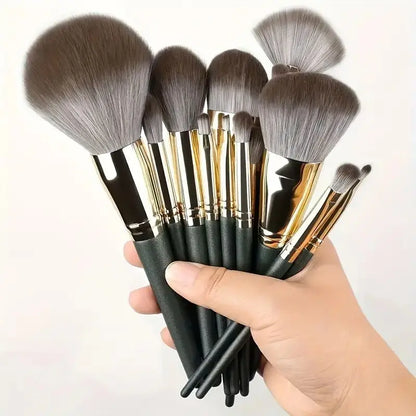 Set of makeup brushes held by a hand on a white background. Soft fluffy makeup brush set with wool fiber bristles and plastic handles. Complete set for powder, foundation, eyeshadow, and beauty blending.