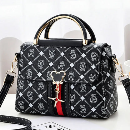 Designer handbag with brand logo and Mickey Mouse charm on a white background
