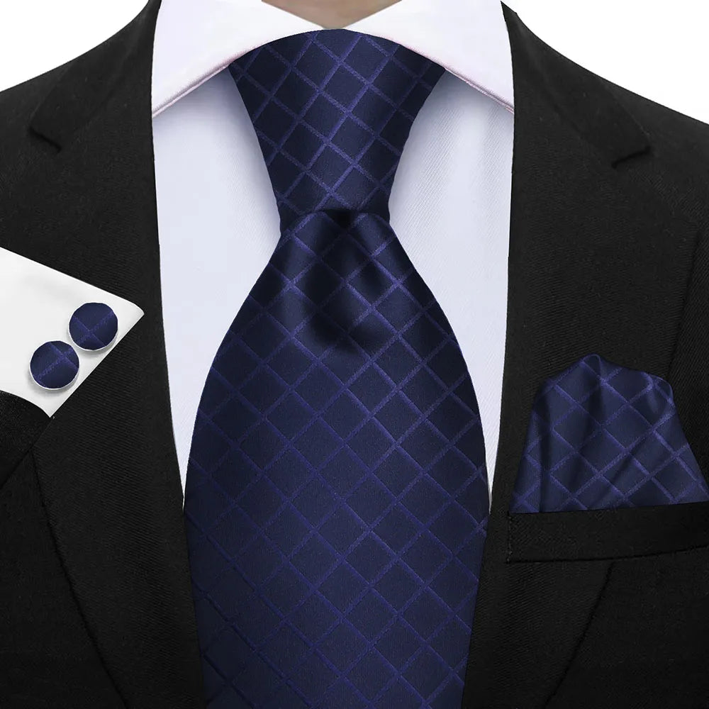 Navy blue tie, pocket square, and cufflinks set on a suit jacket. Elegant men’s 3-piece tie set: striped necktie, floral pocket square, matching cufflinks. Fashionable polyester accessories for formal occasions.