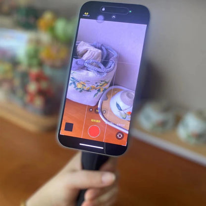 Phone screen showing a photo of a ceramic item with a blurred background. Magnetic phone tripod and wireless grip with remote control. Fits iPhone MagSafe and Samsung devices. Lightweight selfie stick tripod for creators.