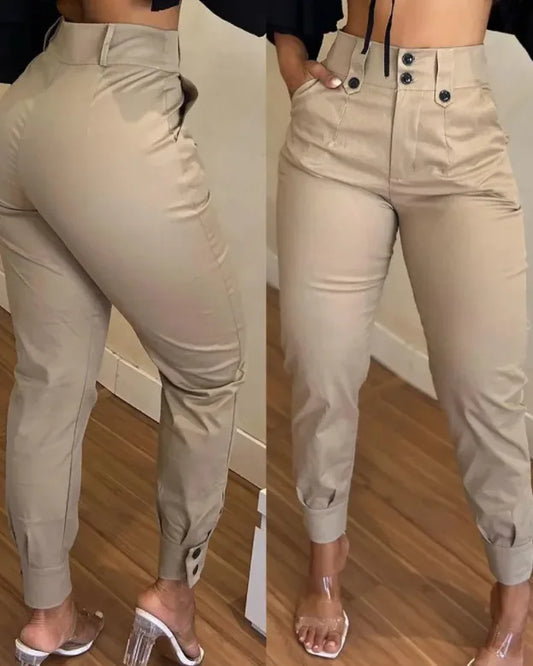 Beige jogger pants worn by a person on a wooden floor.
