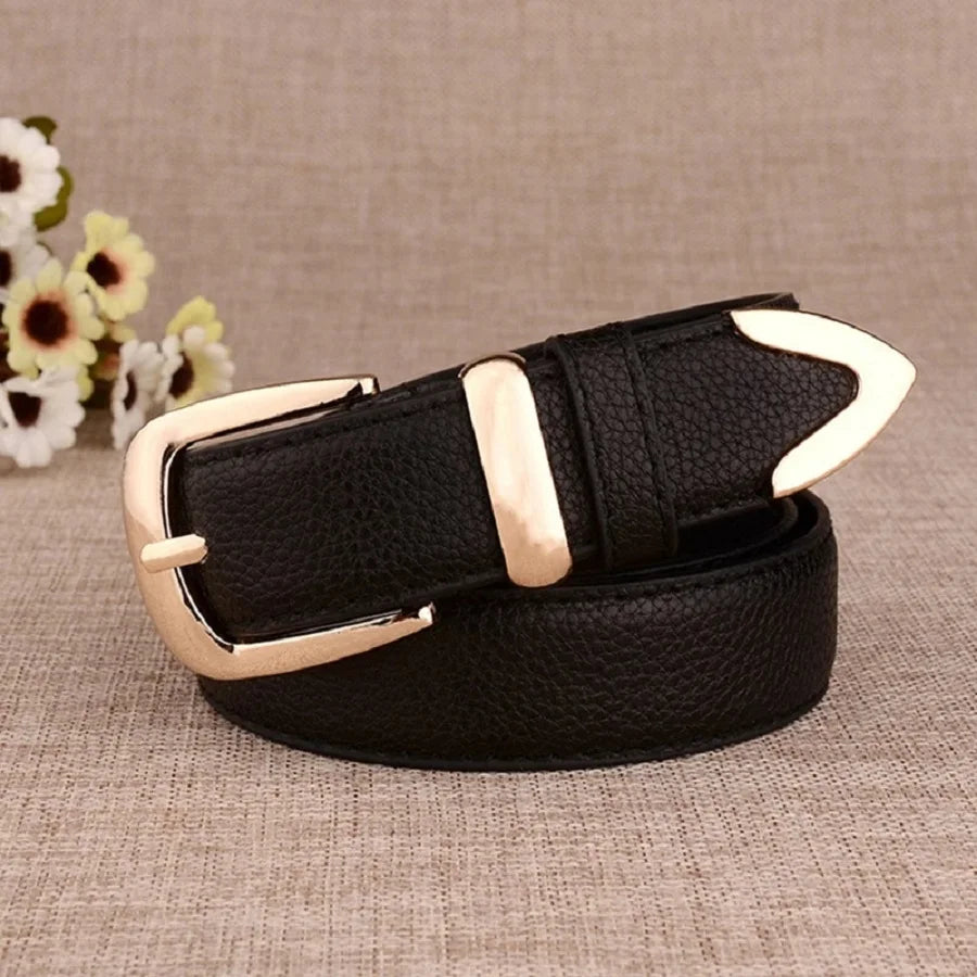 Black belt with gold buckle on a textured surface with flowers in the background. Women’s vintage white leather trouser belt with solid pin buckle. Stylish, high-quality accessory for fashion-forward looks, UK.