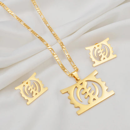 Gold-tone jewelry set featuring a rectangular pendant necklace with a cutout circular symbol, a matching chain, and two matching square earrings, arranged on a white draped fabric background.