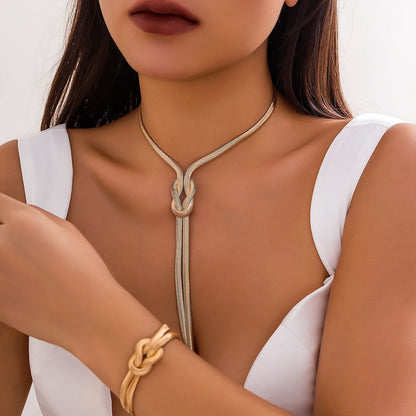Woman wearing a gold necklace and bracelet against a white background. Women’s vintage goth snake twisted chain necklace & bracelet set with tassel, Y2K style jewelry accessories for fashion-forward looks.
