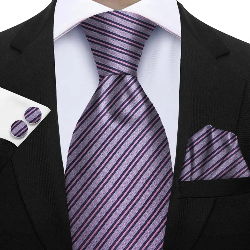 Black suit with a purple striped tie, pocket square, and cufflinks on a white background. Elegant men’s 3-piece tie set: striped necktie, floral pocket square, matching cufflinks. Fashionable polyester accessories for formal occasions.
