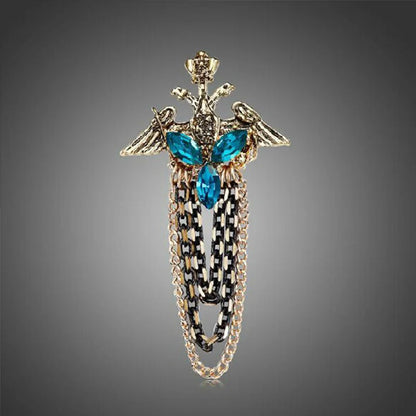 Decorative brooch with blue gemstones and gold chain on a gray background. Elegant rhinestone lapel pins for men and women. Tassel, crown, floral pins for suits, collars, weddings, parties. Zinc alloy metal, classic style.