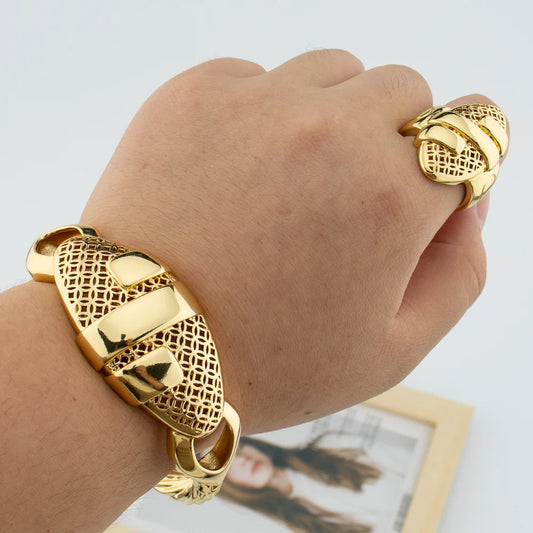 Woman wearing 18K gold plated hollow-out cuff bangle and matching geometric ring on wrist lifestyle shot