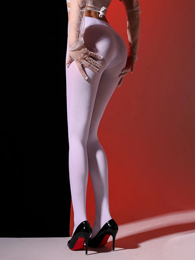 Person wearing white tights and black high heels against a red background
