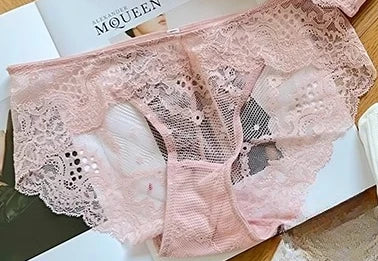 Pink lace lingerie set on a white surface with a magazine in the background.