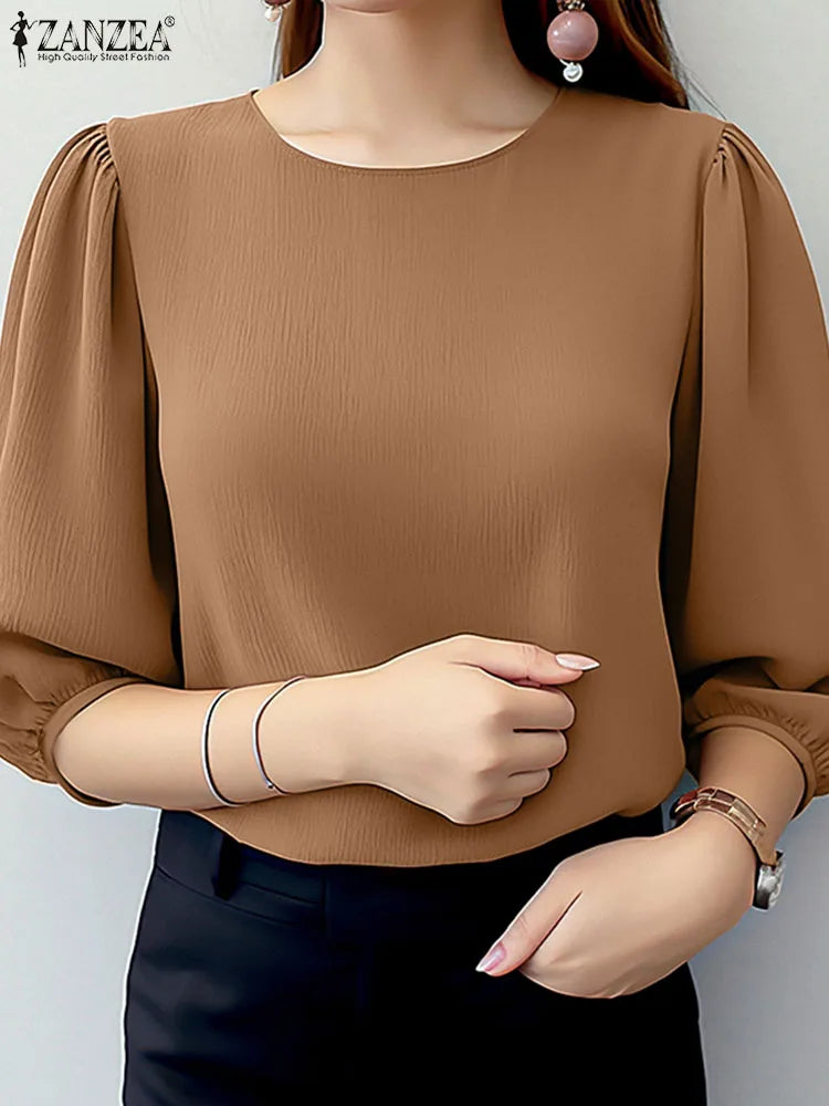 Brown blouse with puffed sleeves worn by a model on a plain background