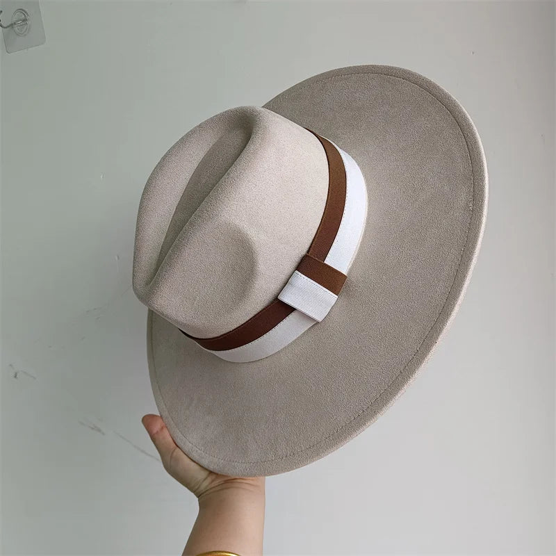 Beige fedora hat with a brown and white band held against a light gray background