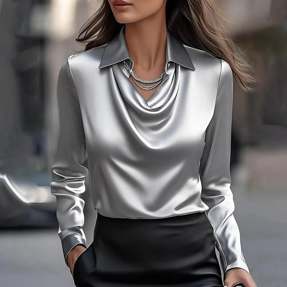 Person wearing a silver blouse with a blurred background
