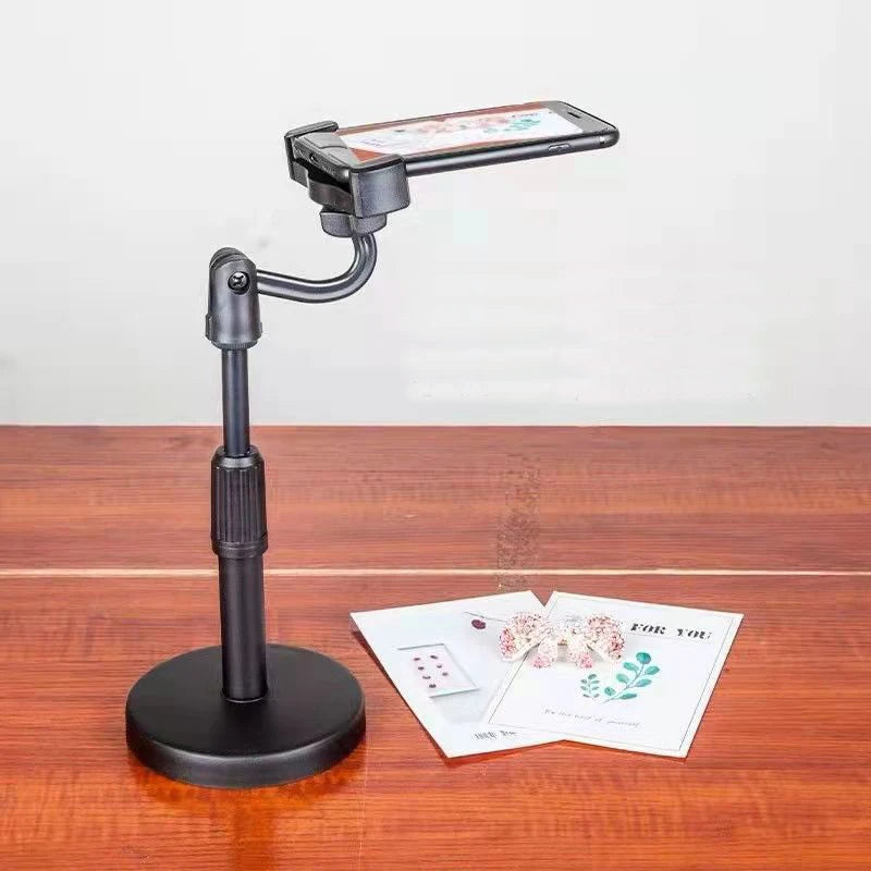 Phone holder on a stand with a white background. Aluminum alloy desktop tripod phone holder stand bracket for iPhone & smartphones. Portable stable tripod perfect for photography, video, live calls.