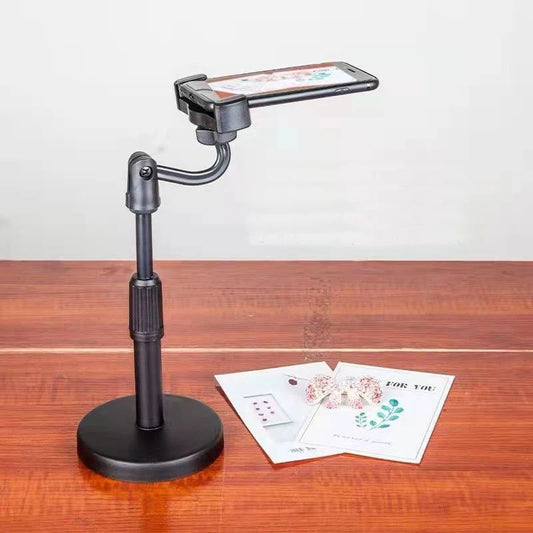 Phone holder on a stand with a white background. Aluminum alloy desktop tripod phone holder stand bracket for iPhone & smartphones. Portable stable tripod perfect for photography, video, live calls.