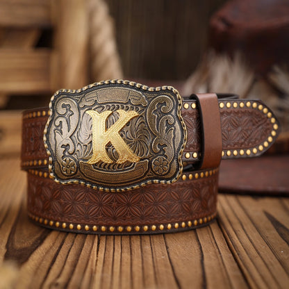 Brown leather belt with gold and silver buckle featuring a large 'K' on a wooden surface.