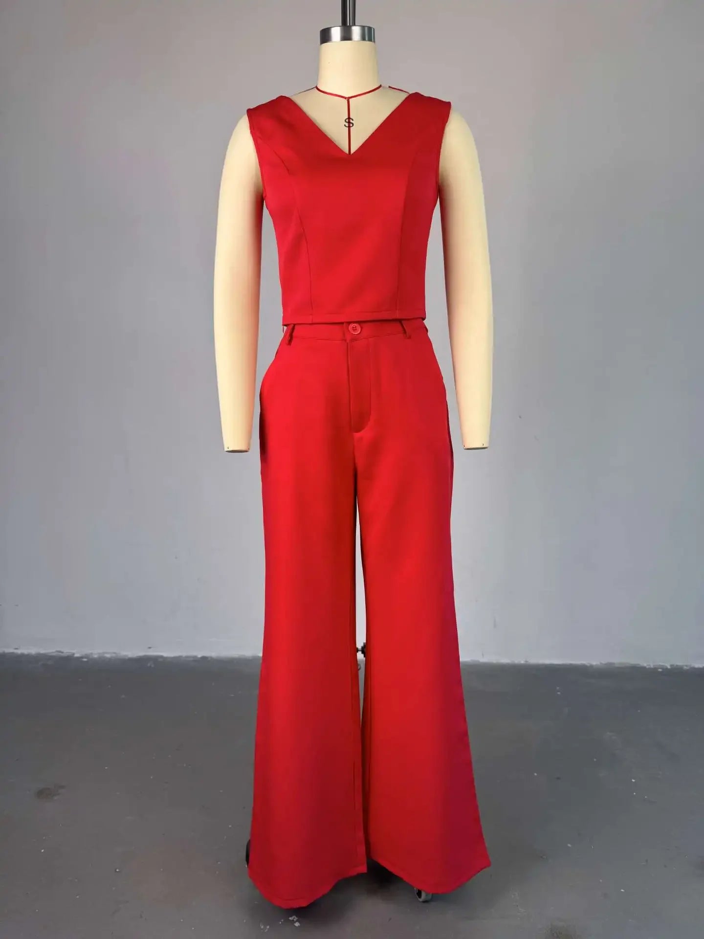 Red jumpsuit on a mannequin against a gray background. Women’s striped print blouse and elastic waist pants two-piece suit. Sleek, comfortable, breathable office wear perfect for spring and summer.