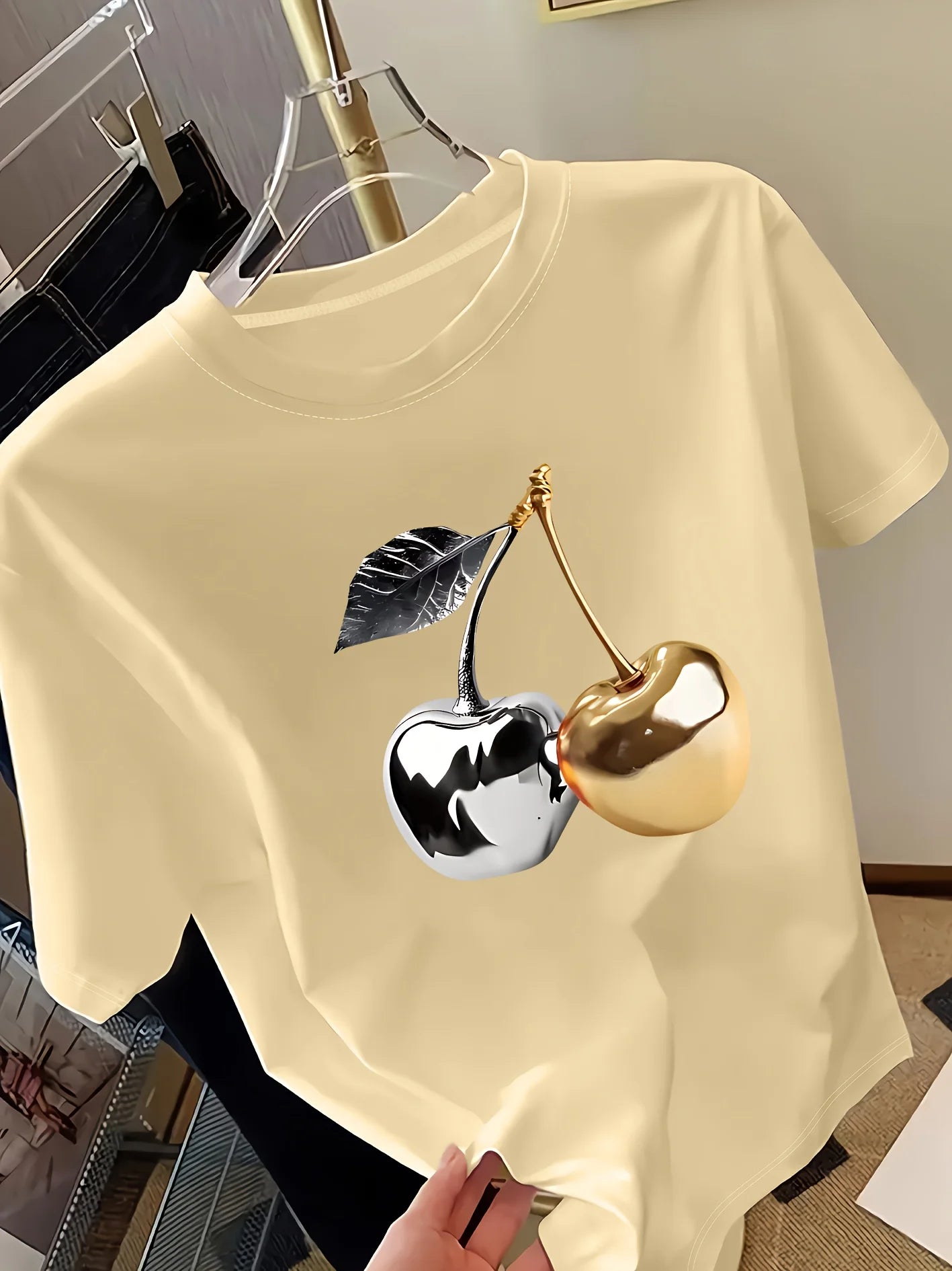 Beige t-shirt with a cherry design on a hanger